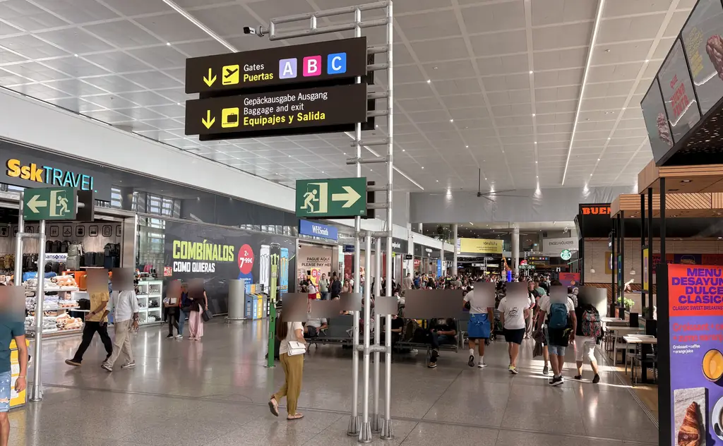 Signs to gates A, B and C and to baggage reclaim and exit inside Málaga Airport