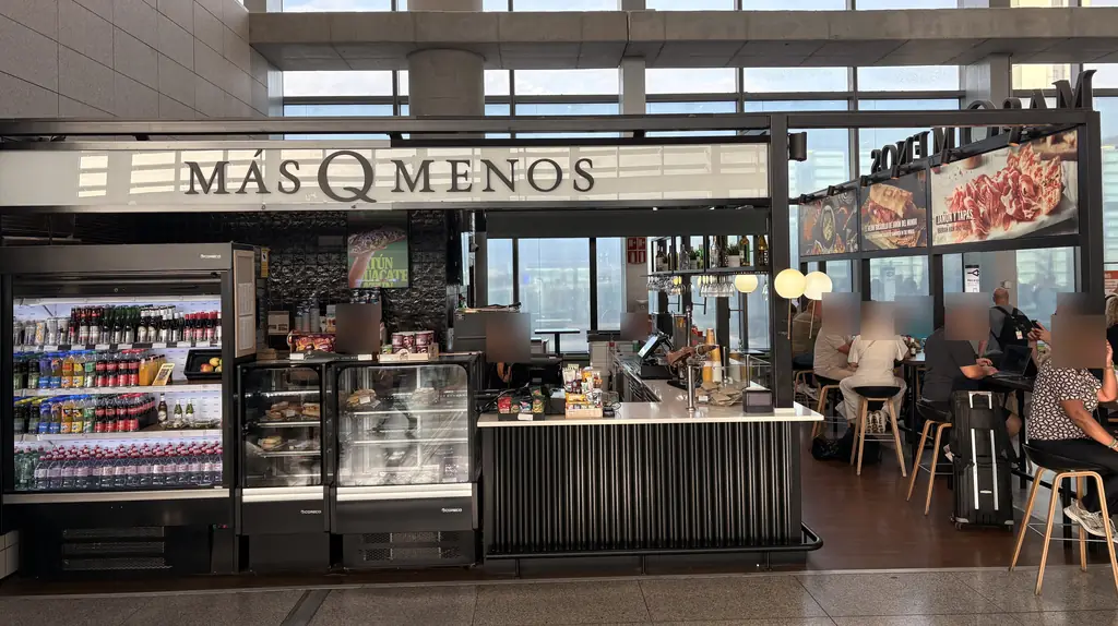 Más Q Menos bar with drinks fridges and seating in the Málaga Airport departure area