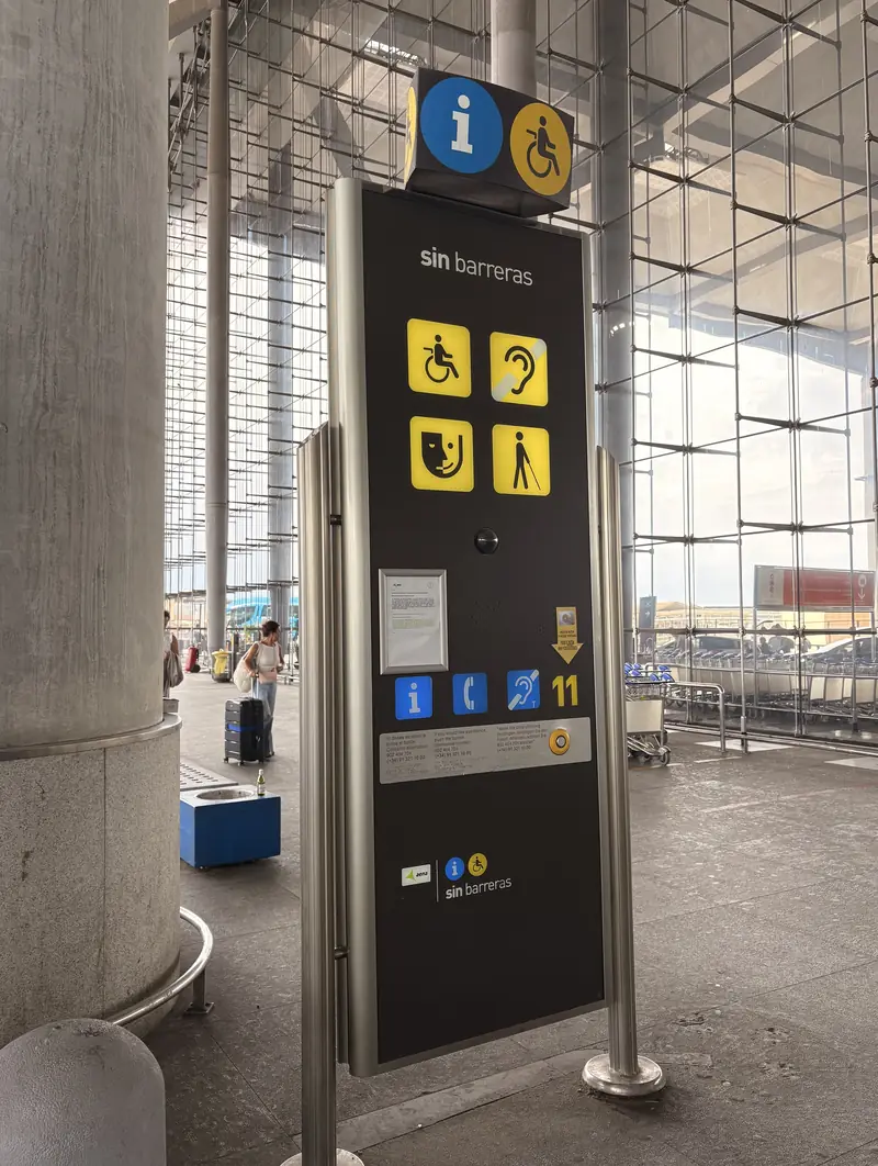Aena Sin Barreras assistance point at Málaga Airport with accessibility symbols, information panel and call button